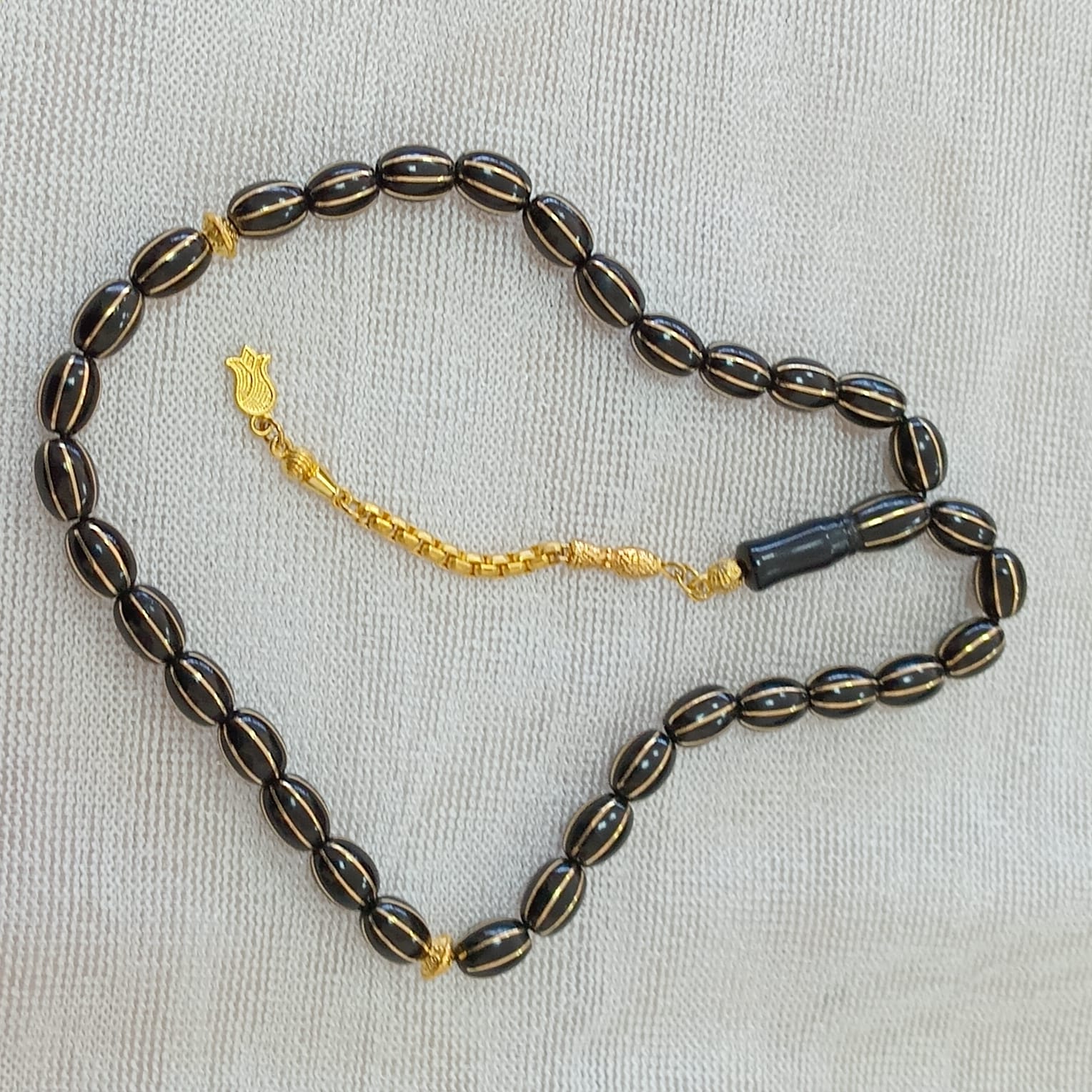 Oval-Cut Press Oltu Stone Tasbih with Brass Melon-Slice Inlay, 7.5x10.5mm