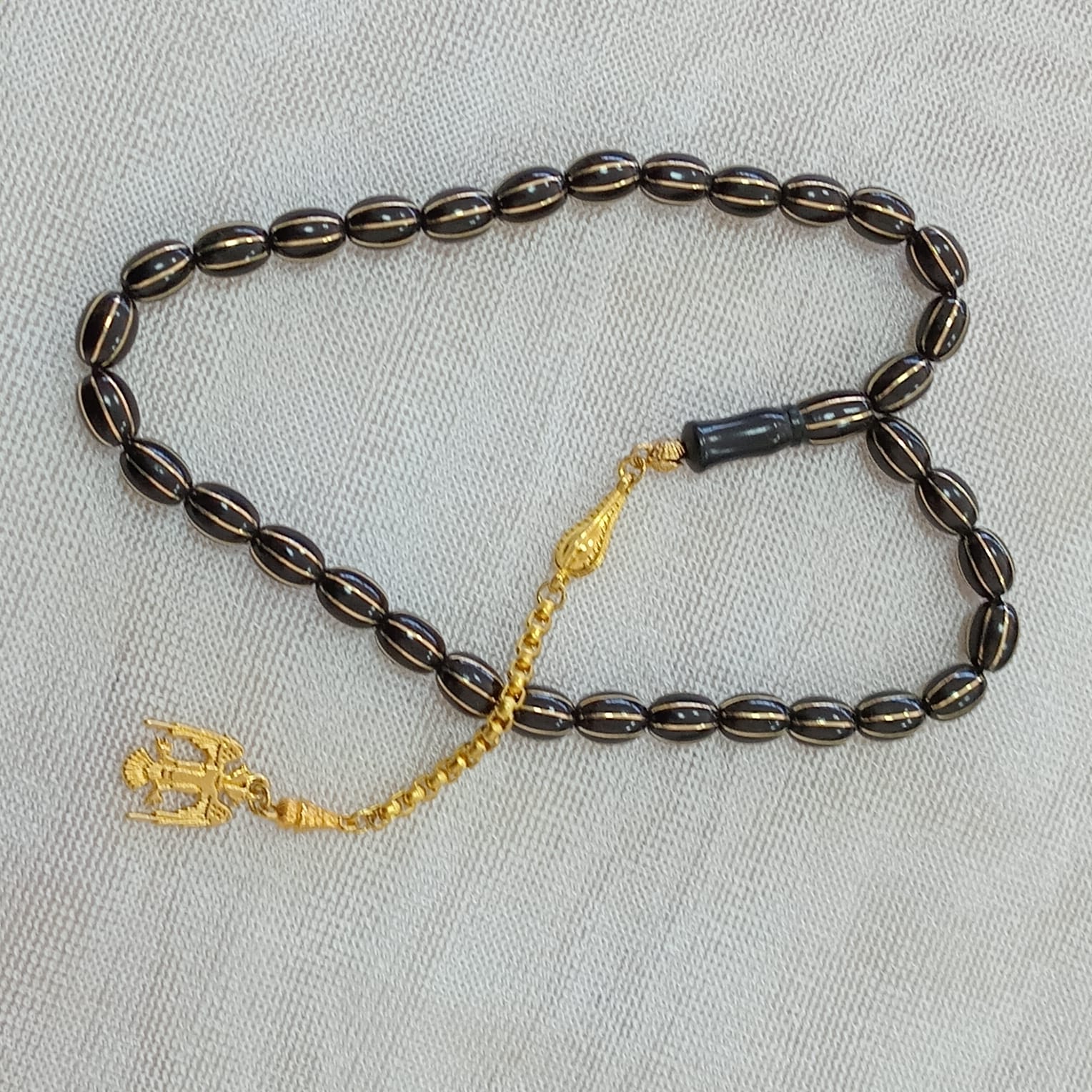Oval-Cut Press Oltu Stone Tasbih with Brass Melon-Slice Inlay, 7.5x10.5mm