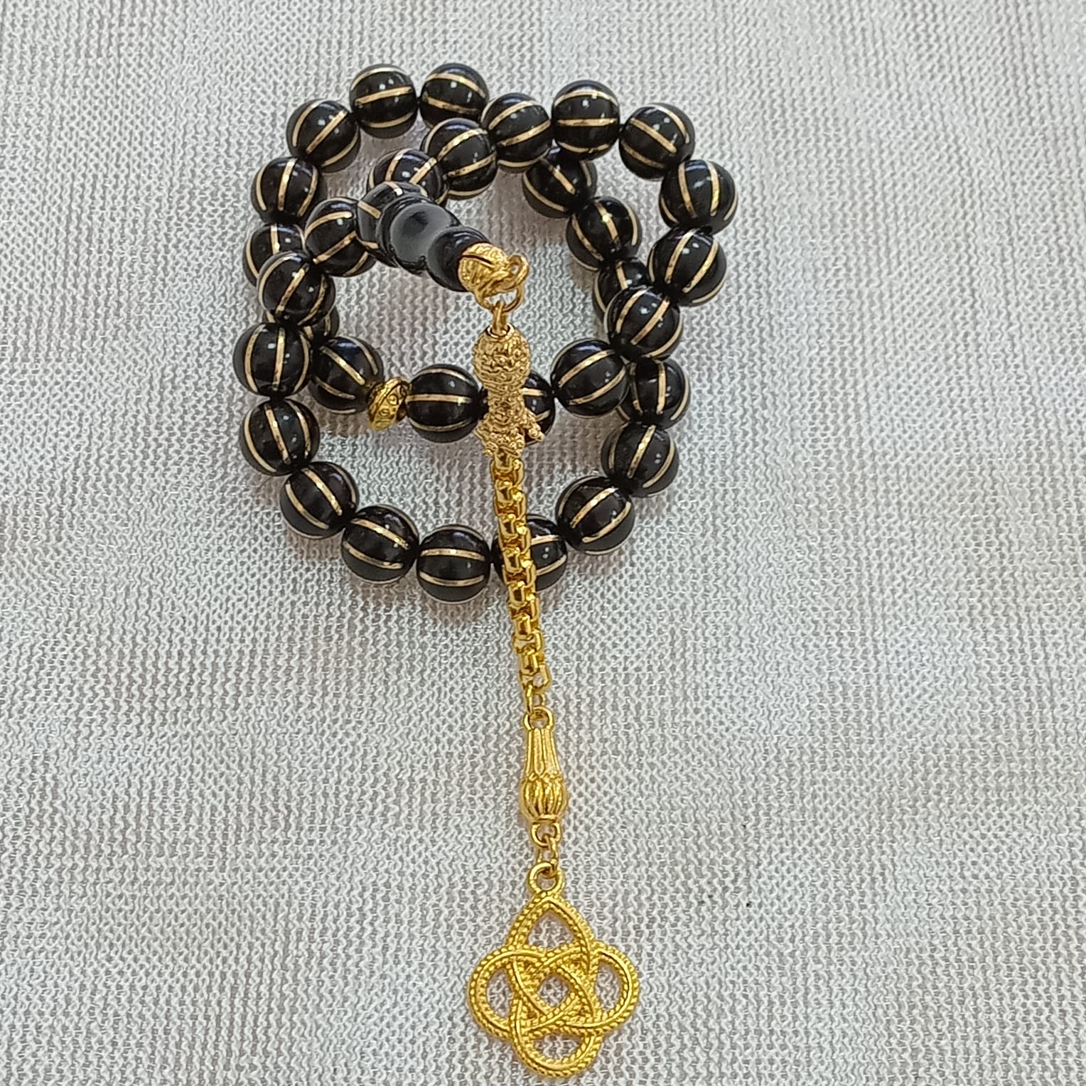 Oval-Cut Press Oltu Stone Tasbih with Brass Melon-Slice Inlay, 7.5x10.5mm